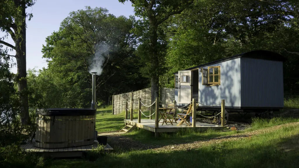 Plankbridge shepherd's hut next to a lake